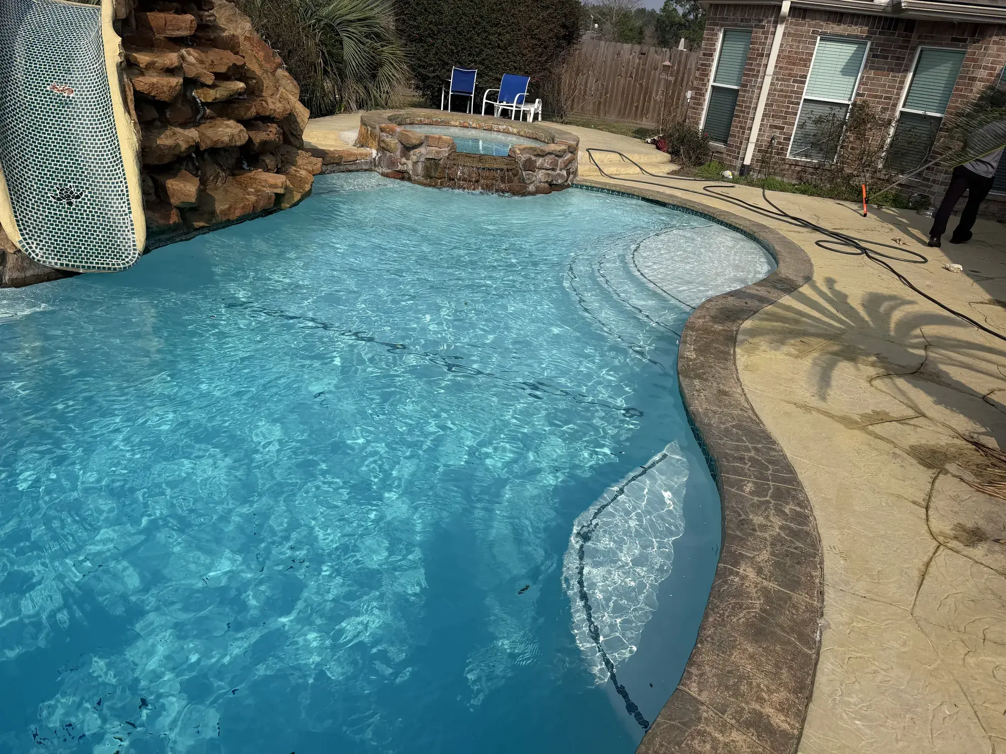 Finished backyard pool installation with stone coping and tile accents in East Texas