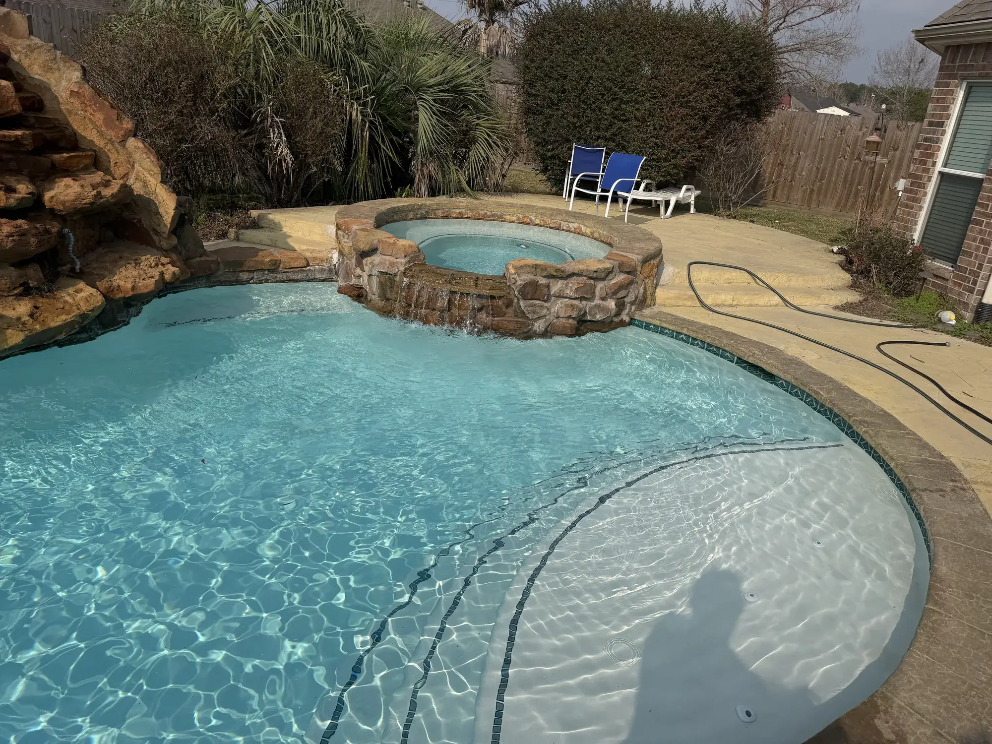 Custom backyard pool with sun deck and modern tile by Sam Houston Pools and Outdoors