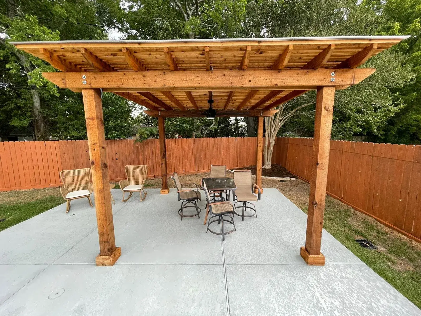 Custom cedar pergola over a poolside patio in a Houston-area backyard, designed and built by Sam Houston Pools and Outdoors