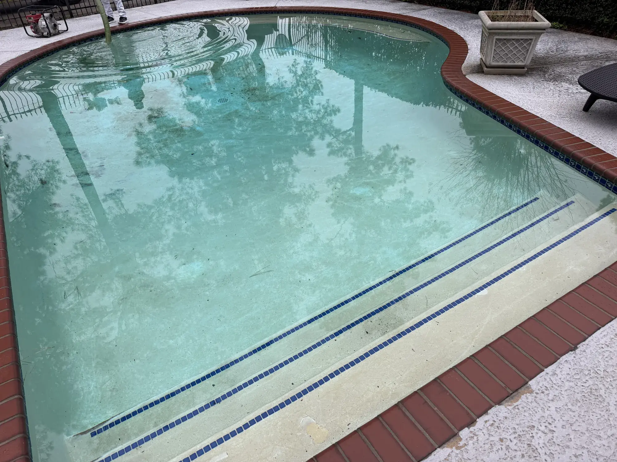 Custom in-ground gunite pool with attached spa and waterline tile in a residential backyard