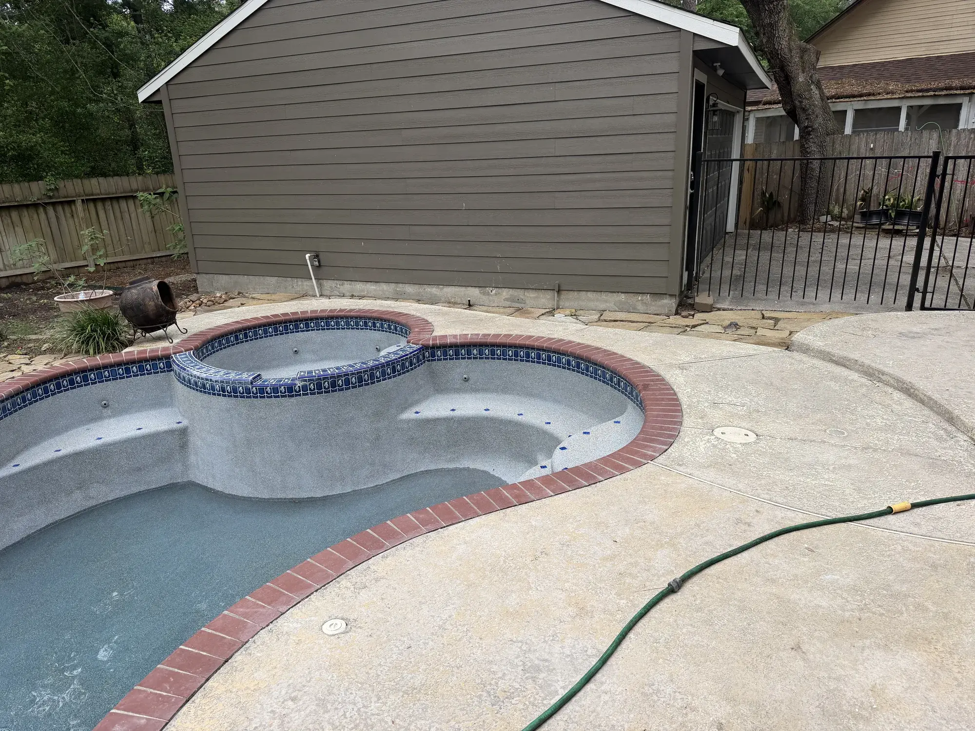 Luxury backyard swimming pool with deck jets and modern coping, built by Sam Houston Pools and Outdoors in East Texas