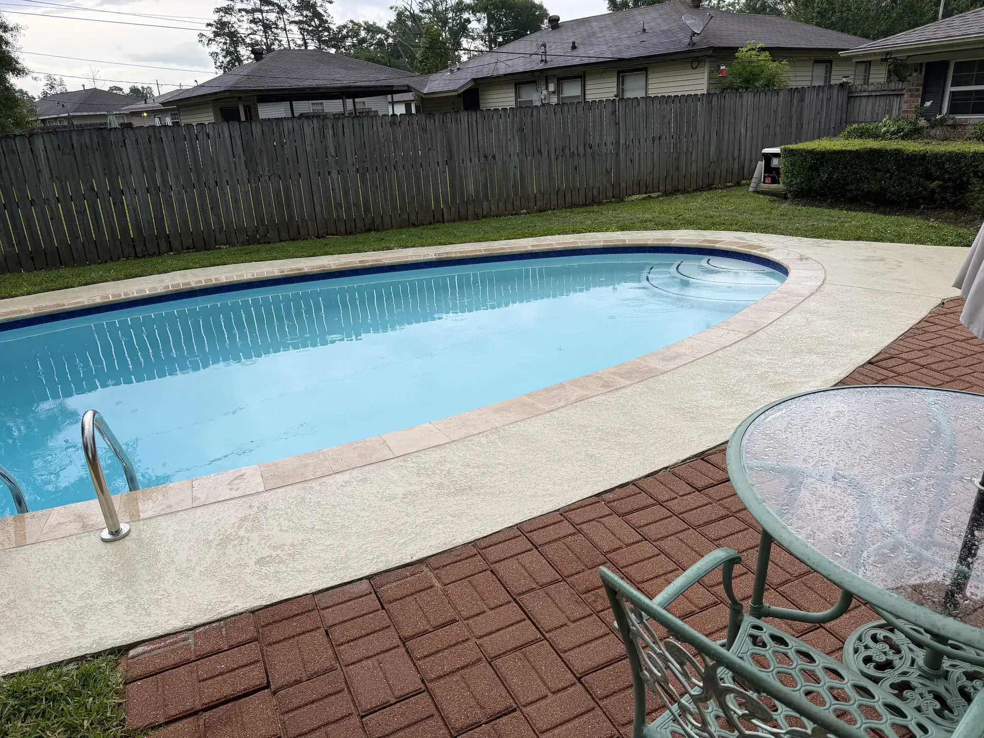 Contemporary in-ground pool with raised spa and sleek tile work in an East Texas backyard