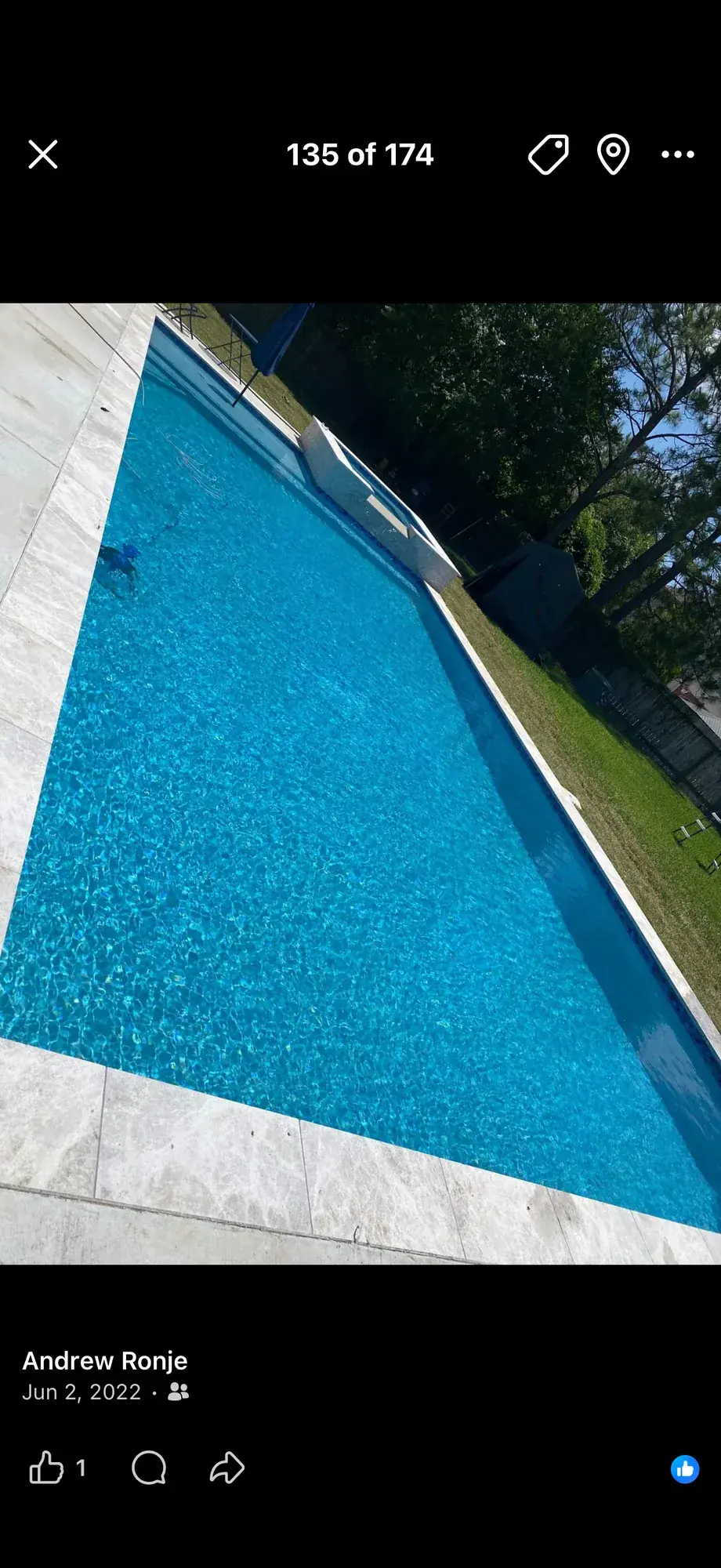 Geometric rectangular in-ground pool finished with a travertine deck in an East Texas backyard