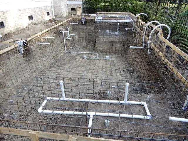 Rough plumbing run alongside the rebar stage of a custom pool build by Sam Houston Pools and Outdoors