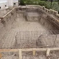 Steel rebar framework installed in an excavated pool shell during gunite pool construction in East Texas