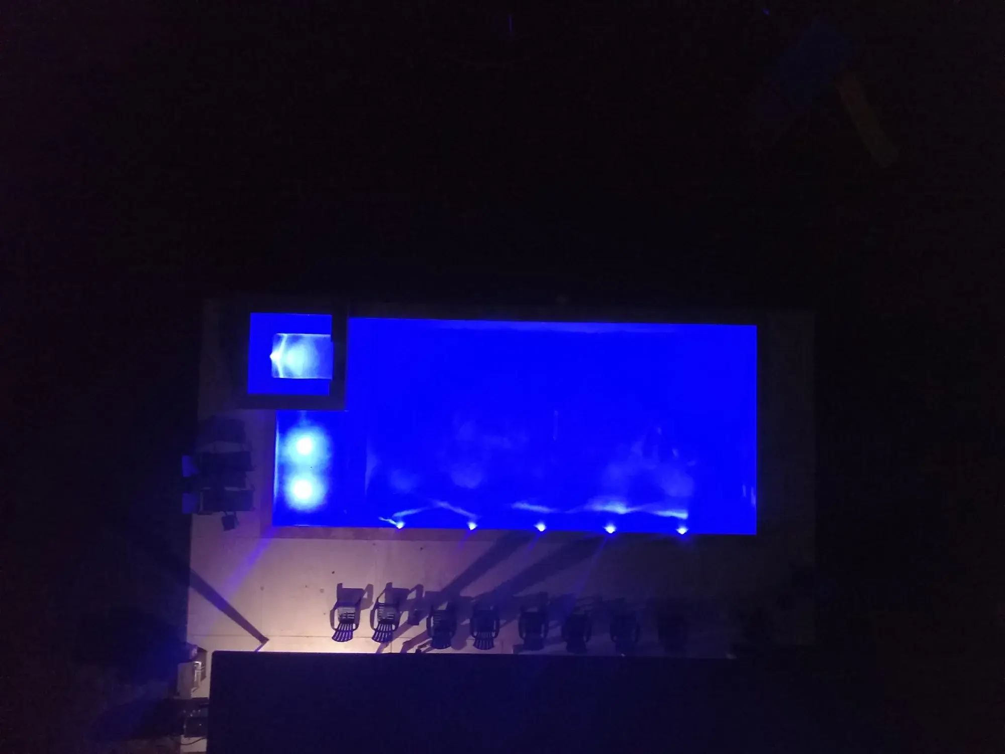 Modern pool illuminated at night with LED lighting and running water features — examples of equipment installed and serviced by Sam Houston Pools and Outdoors